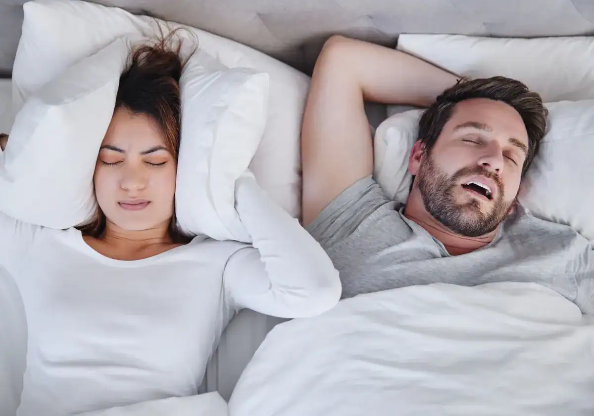 Restless couple sleeping in bed, discomfort, sleep issues, dental health concern.